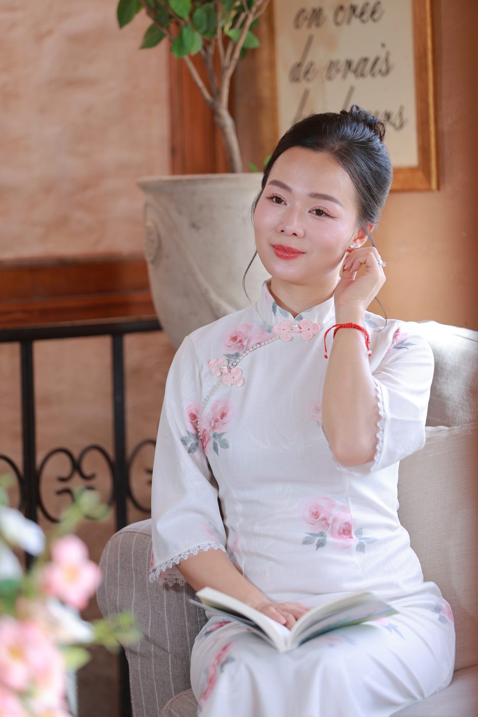 Elsa Phương trong áo dài họa tiết hoa hồng, ngồi đọc sách